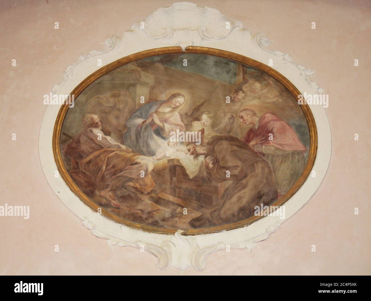 Mombello, Limbiate, Lombardy, Italy. Oratory of St. Francis (Oratorio di San Francesco), next to the Villa Pusterla Crivelli, is an important work by Francesco Croce, architect of the major spire of Milan Cathedral. Here, on June 14, 1797, the sisters of Napoleon Bonaparte Paolina and Elisa were married. Interior, left lateral oval, adoration of the child Jesus with Mary, Joseph, St. Francis of Assisi and St. Charles Borromeo. The fresco is attributed to Francesco Angelo Borroni (circa 1754). Stock Photo