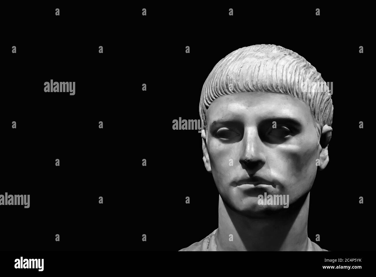 Black and white photo in close-up of head of ancient roman marble sculpture of a young man with short hair Stock Photo