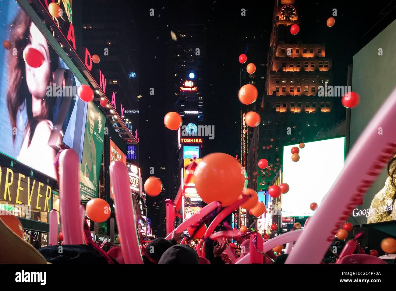 Manhattan, New York, United States of America - The Times Square New Year's Eve celebration famous for Ball Drop. Cheering crowds with balloon sticks. Stock Photo