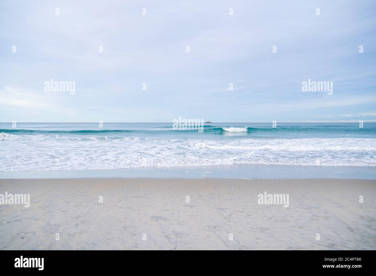 Soft blue ocean wave on sandy beach. Background textured. Stock Photo