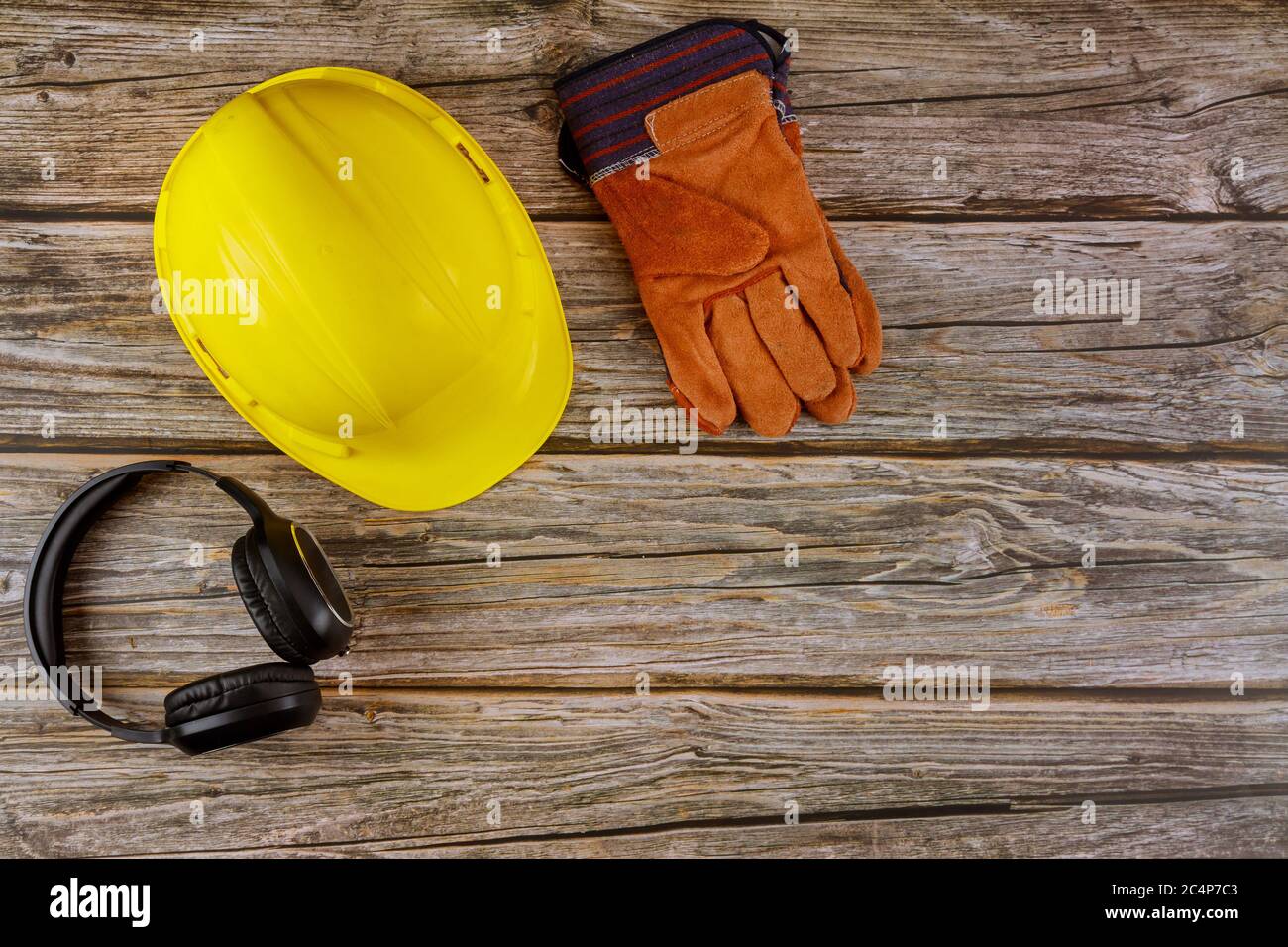 Equipment safety standard construction safety earmuffs leather safety helmet protective gloves on wooden table top view Stock Photo