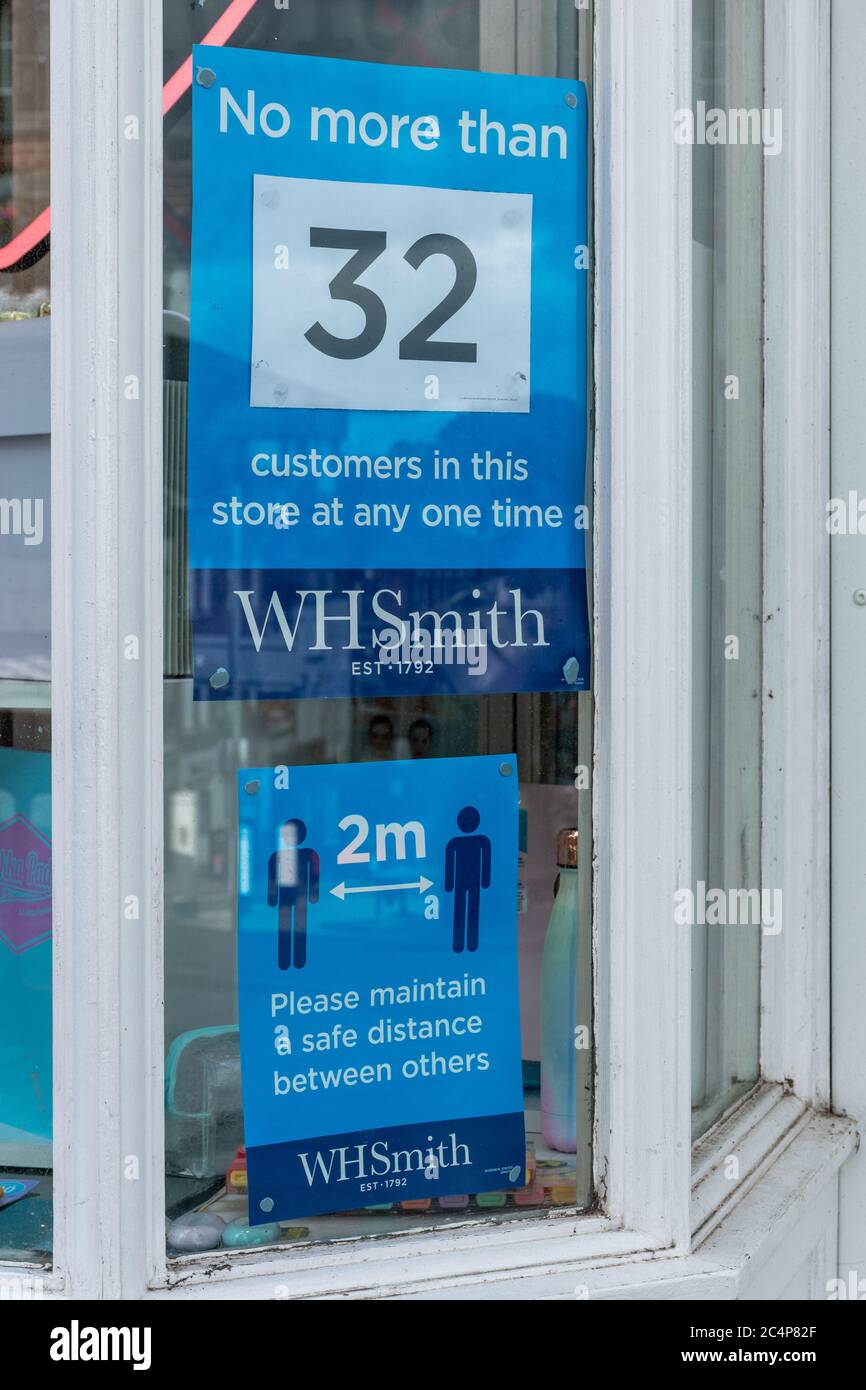 Notices saying No more than 32 customers in this store at any one time, WH Smith shop reopened during coronavirus covid-19 pandemic, June 2020 Stock Photo