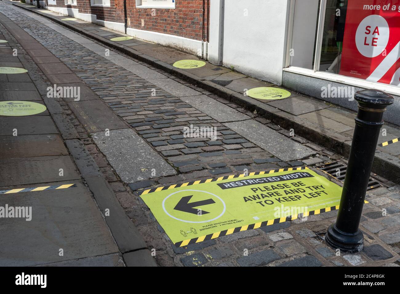 Signage on narrow street in Guildford town centre asking people to keep left after easing of lockdown during coronavirus covid-19 pandemic, june 2020 Stock Photo