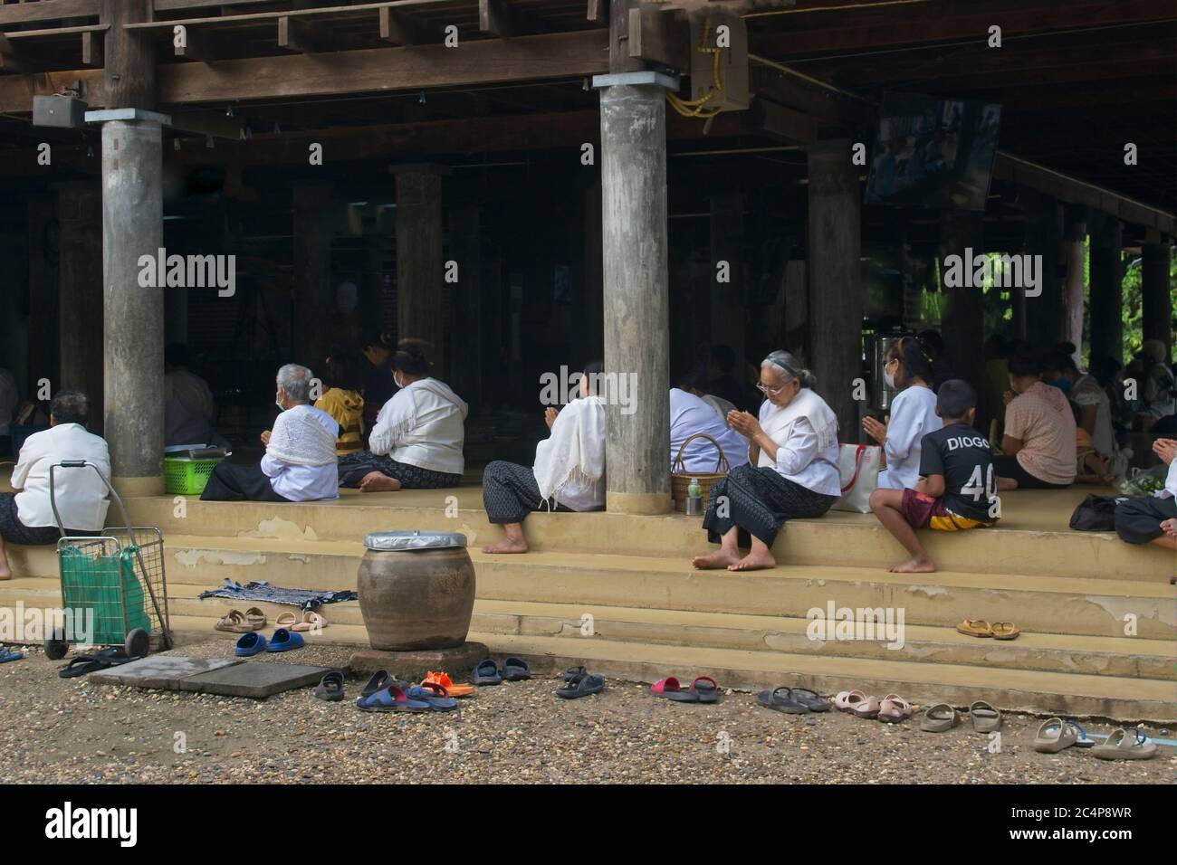 Celebrating Buddhist Monks' Day. Temple surroundings people sitting ...