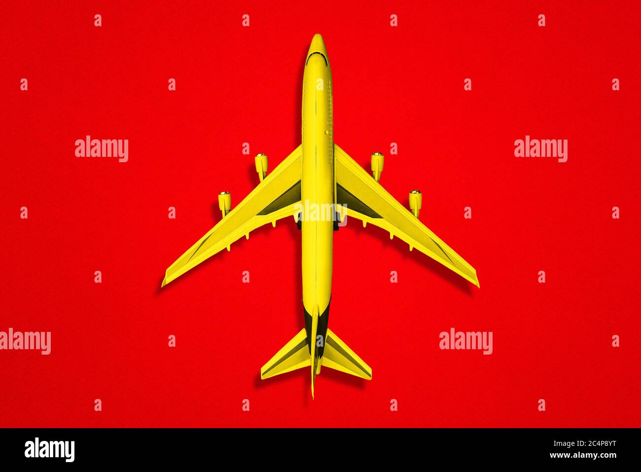 Yellow plane on a red background. A top view of a flat layout. Stock Photo