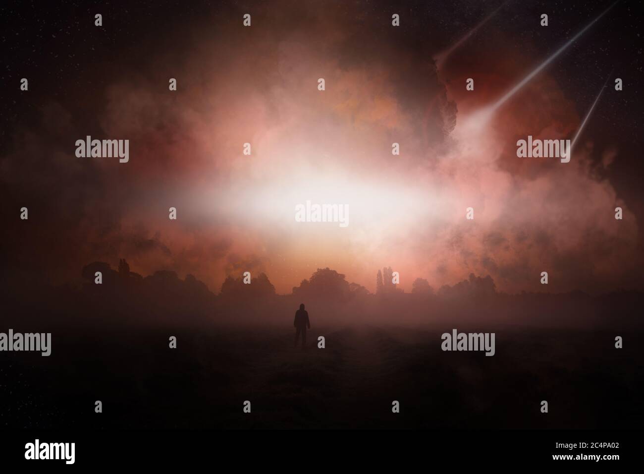 A post apocalypse scene showing a man standing, looking at asteroid falling from the sky. Stock Photo