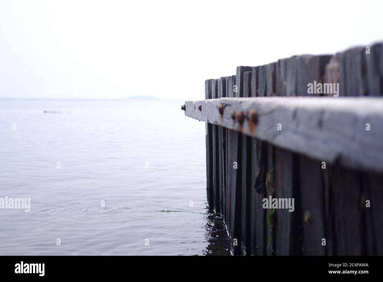 Rotting wood plank at beach, either for small boat dock or wave breaker Stock Photo Alamy
