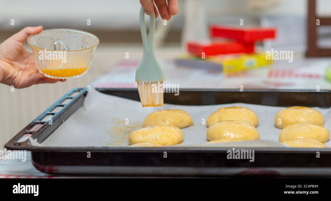 Uncooked dough rolls on the tray with egg yolk Stock Photo