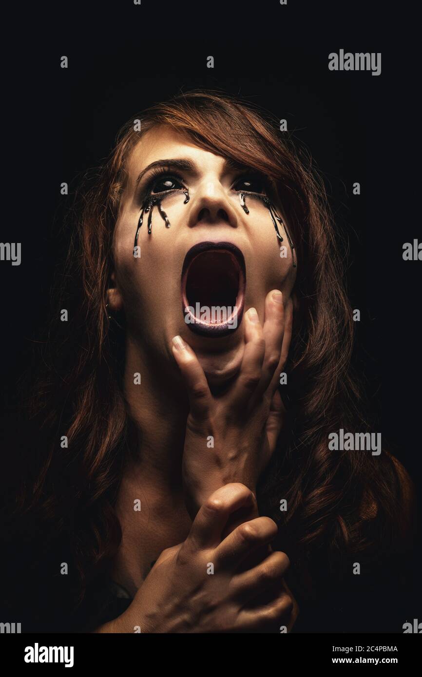 Horror Scene With Screaming Scary Human Face With A Harsh Light On A Black  - Halloween Concept With Young Man With Open Mouth And Teeth Stock Photo,  Picture and Royalty Free Image.