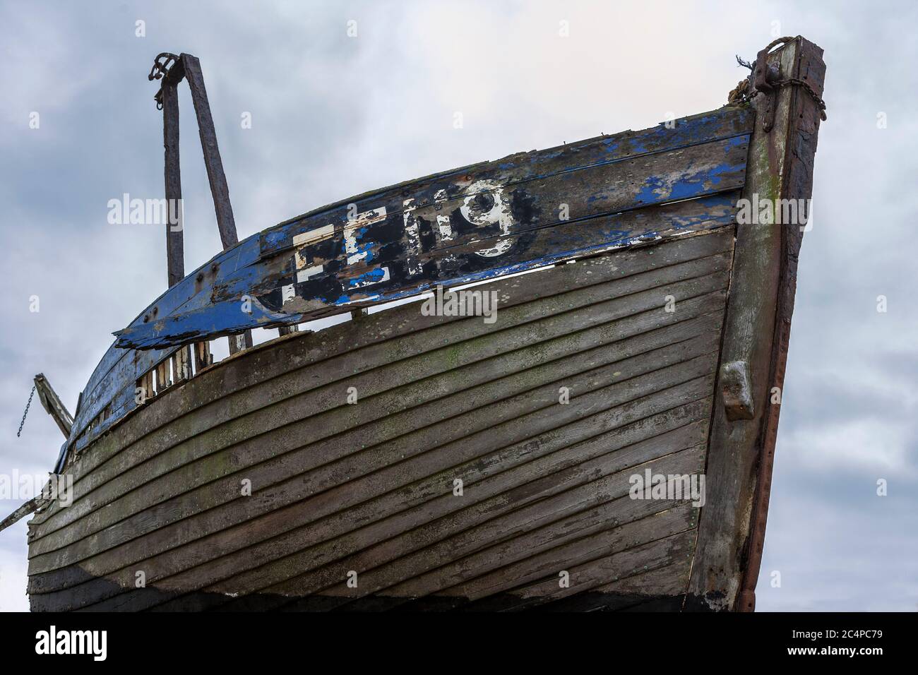 The wreck of an old wooden fishing boat on the shingle beach at ...