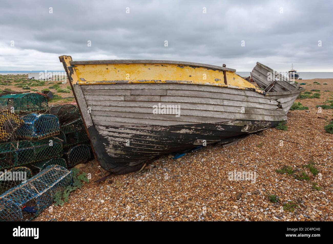 The wreck of an old wooden fishing boat on the shingle beach at ...