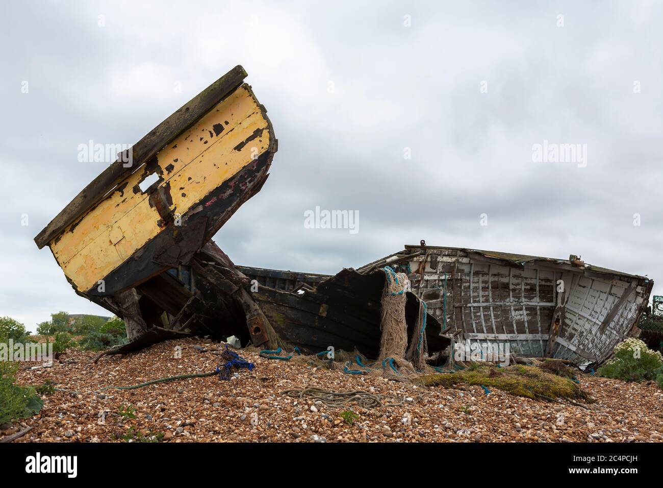The wreck of an old wooden fishing boat on the shingle beach at ...