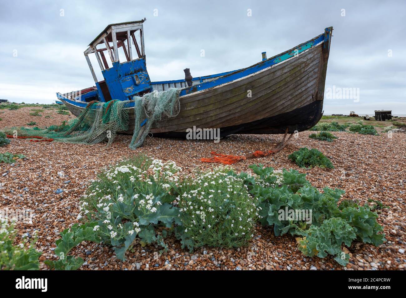 The wreck of an old wooden fishing boat on the shingle beach at ...