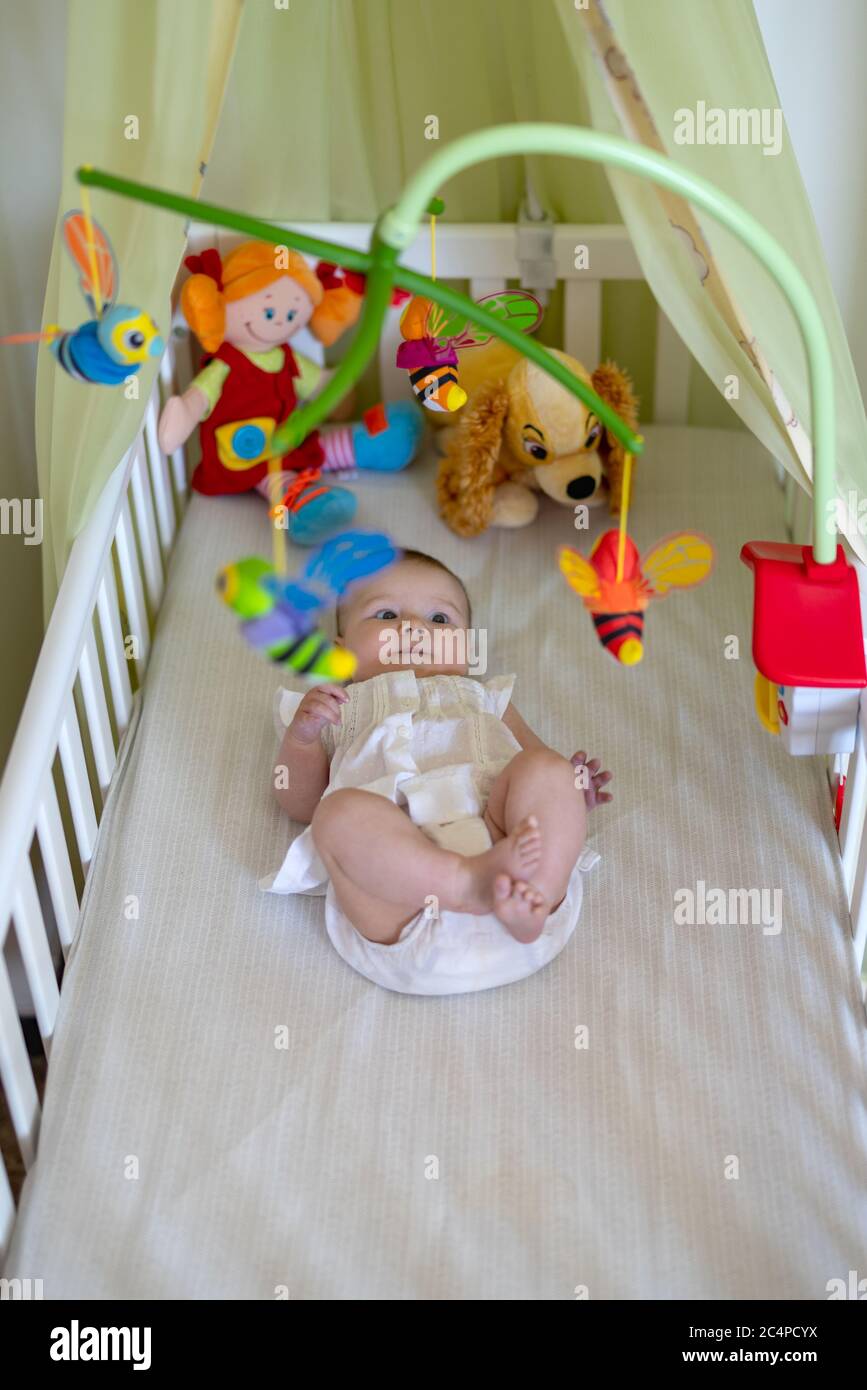 Baby girl lying in cot hi-res stock photography and images - Alamy