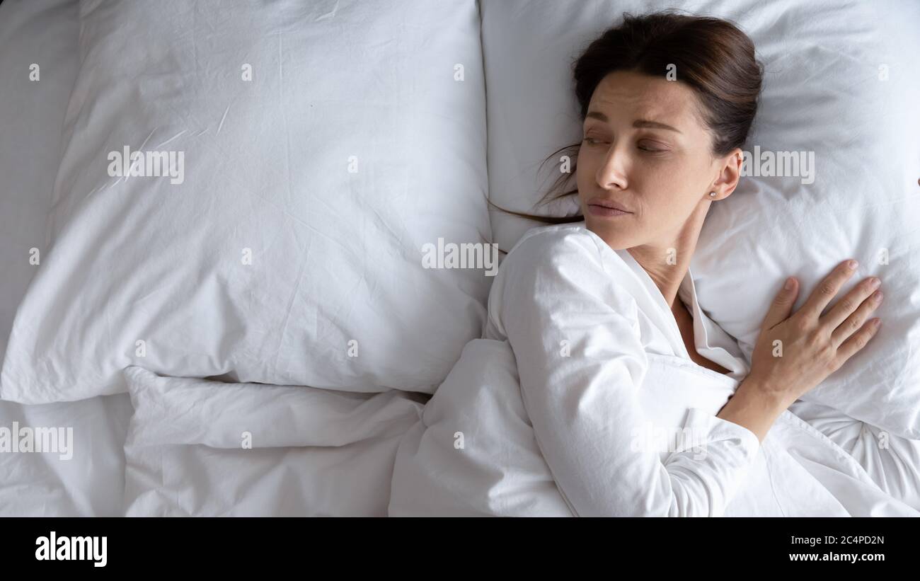 Sad young woman lying in bed feeling lonely Stock Photo Alamy