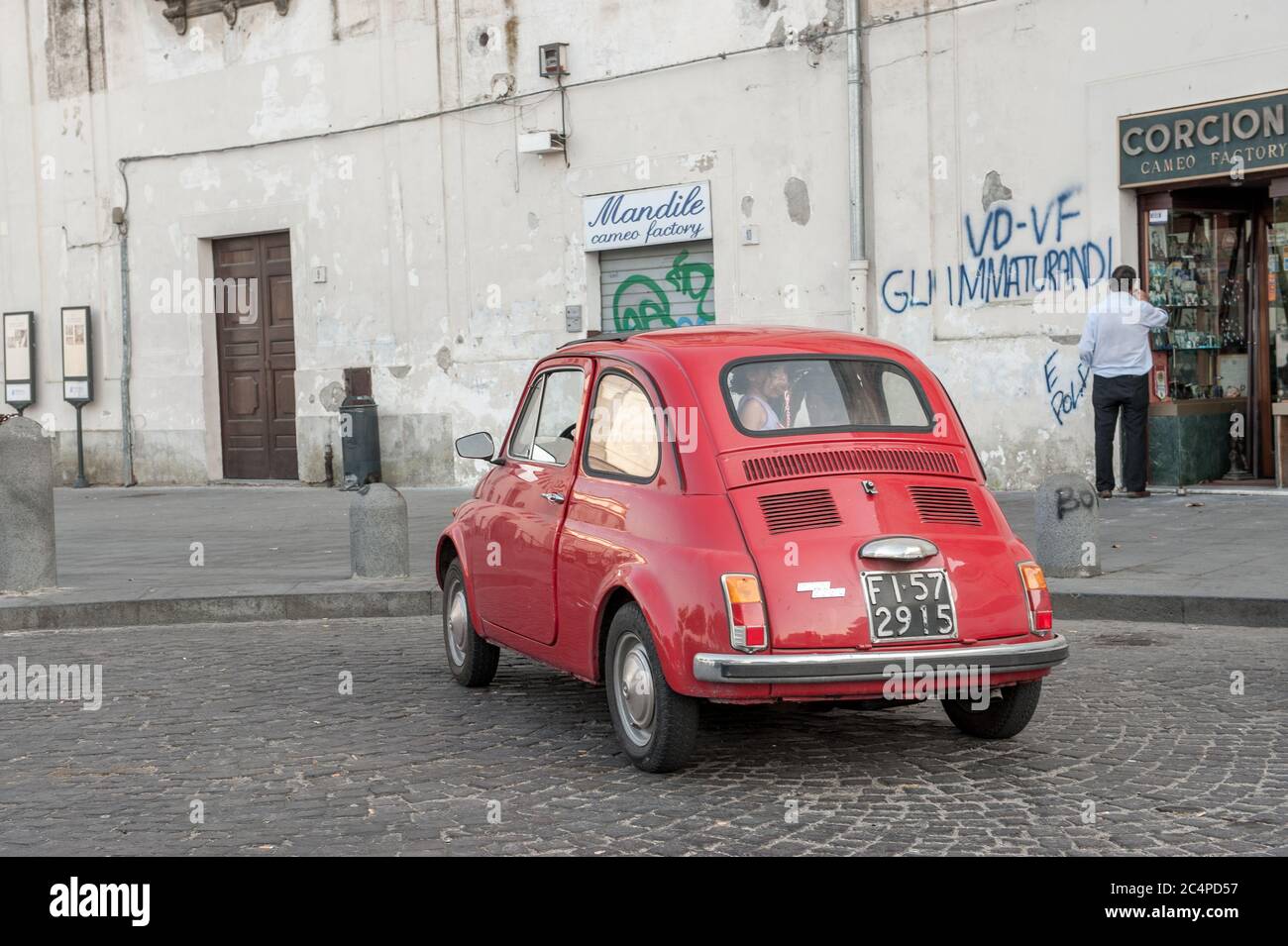 Old Fiat 500 parked at a small square in Naples, Italy. Tiny cars are preferable inthe narrow alleys of Naples. Stock Photo
