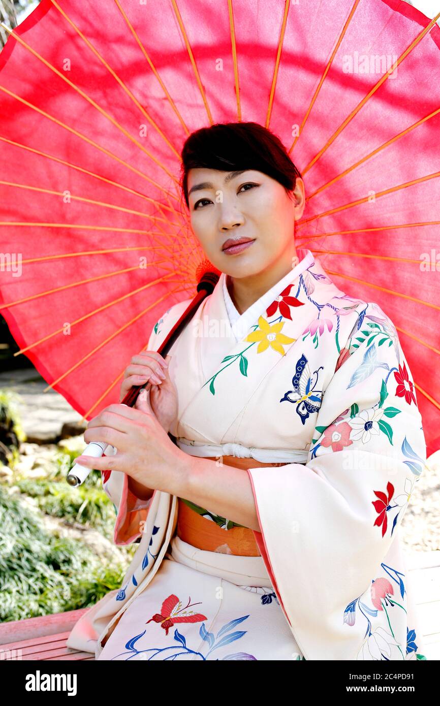 Portrait of Japanese woman wearing white kimono in cherry blossoms