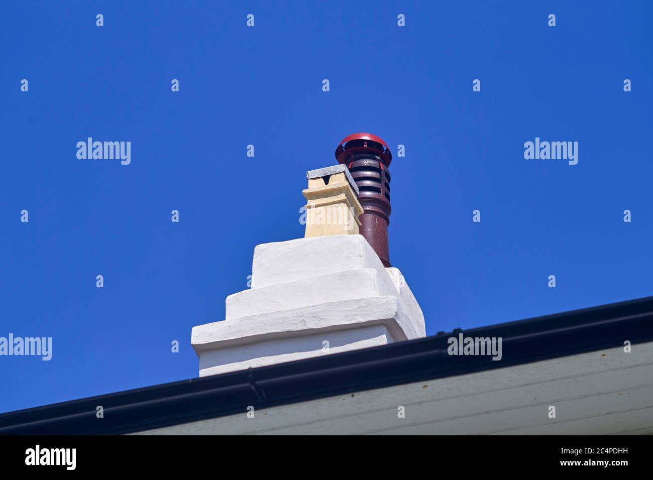 Looking up from ground at chimney stack on victorian house with wood burning stove fitted and lead covering Stock Photo