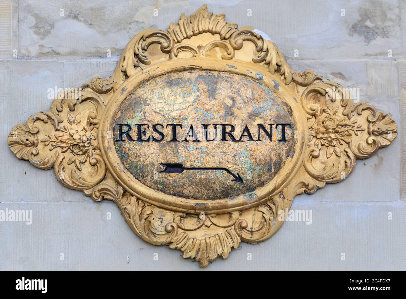 Elaborate gilded restaurant hospitality sign in baroque style on exterior stone wall Stock Photo