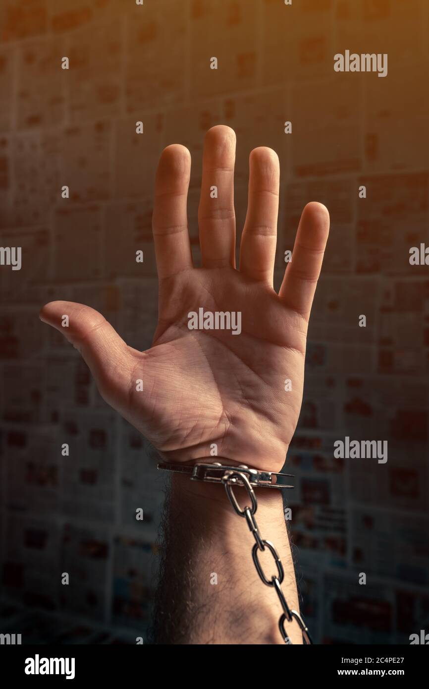 Handcuffed arrested journalist protesting with raised hand pleading for help, conceptual image Stock Photo
