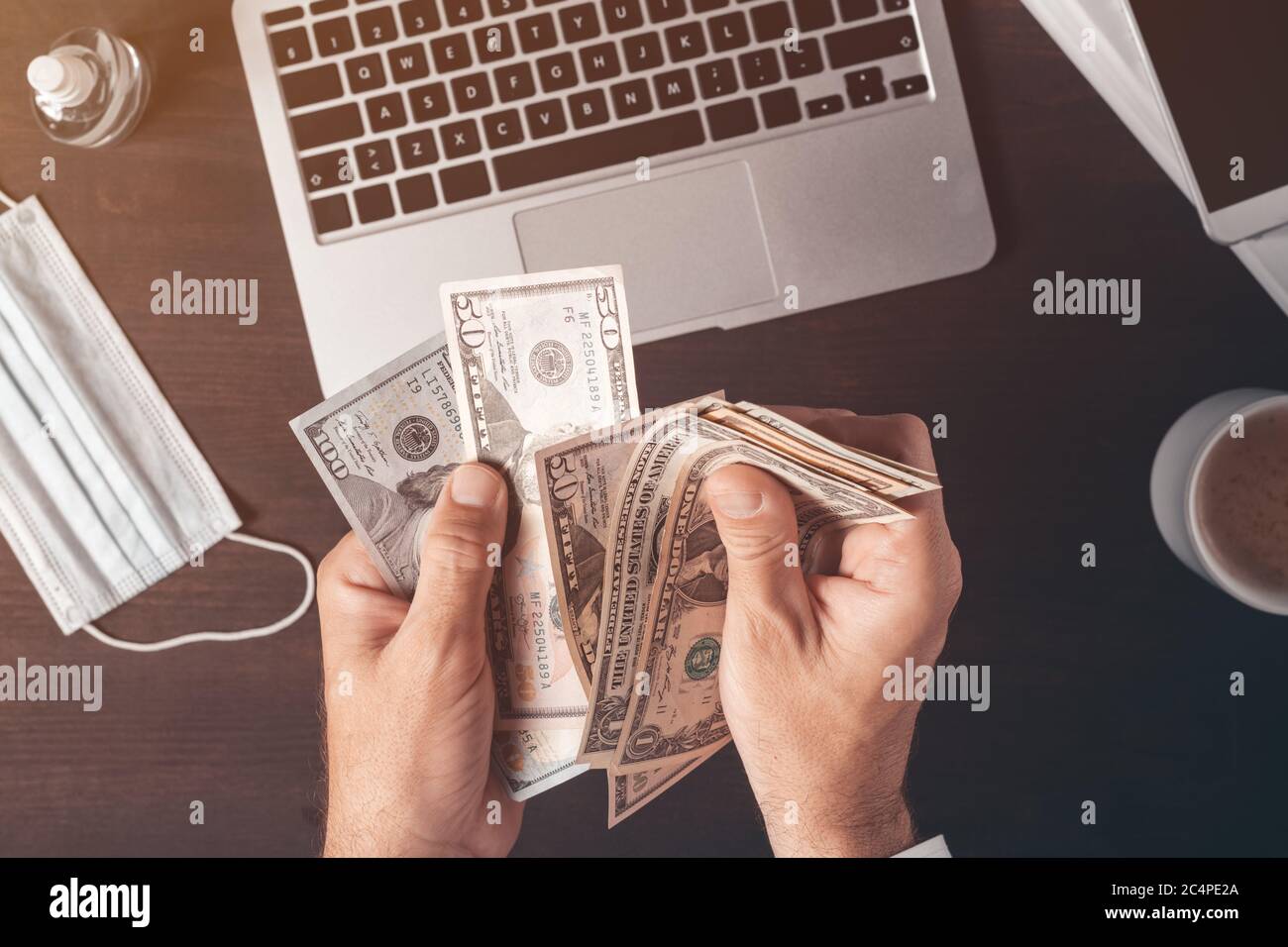 Businessman counting american dollar paper currency cash at office desk, top view of male hands with money Stock Photo