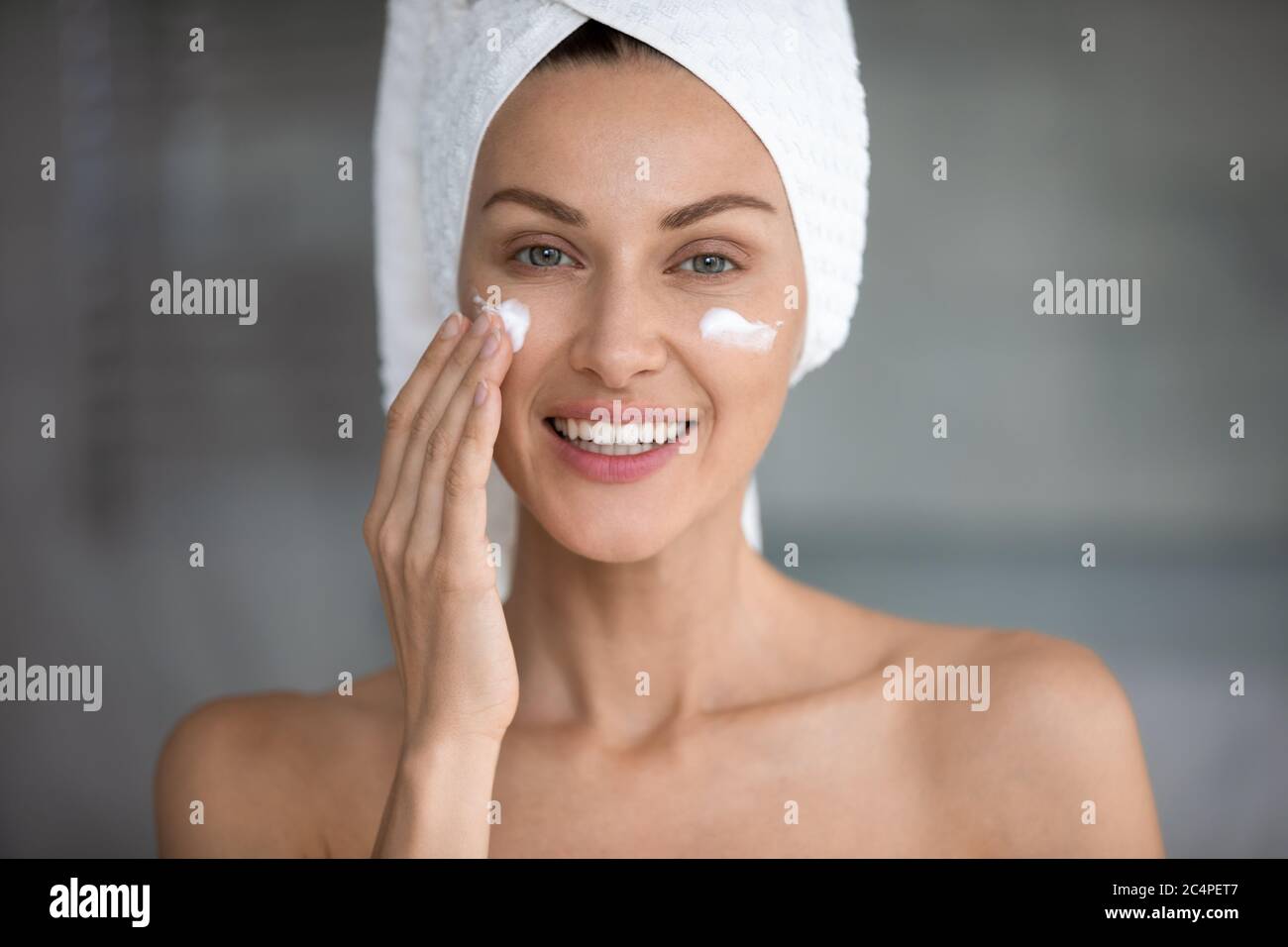 Young woman use revitalizing facial cream in bathroom Stock Photo Alamy