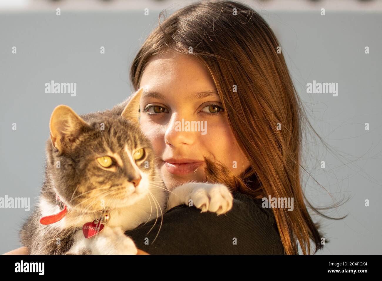Young smiling girl catching her cat Stock Photo