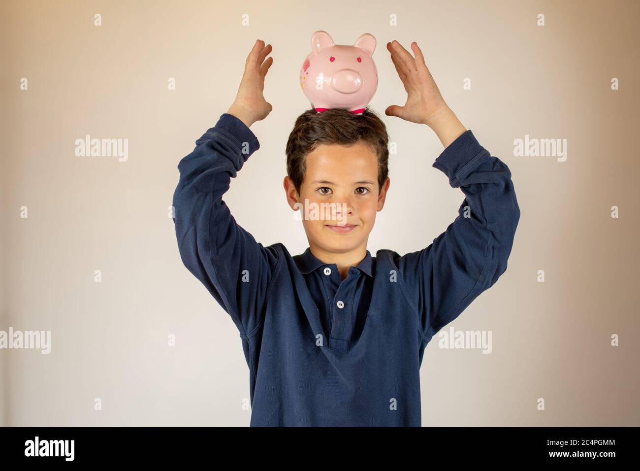 Smiling young boy with a piggy bank in his head Stock Photo - Alamy
