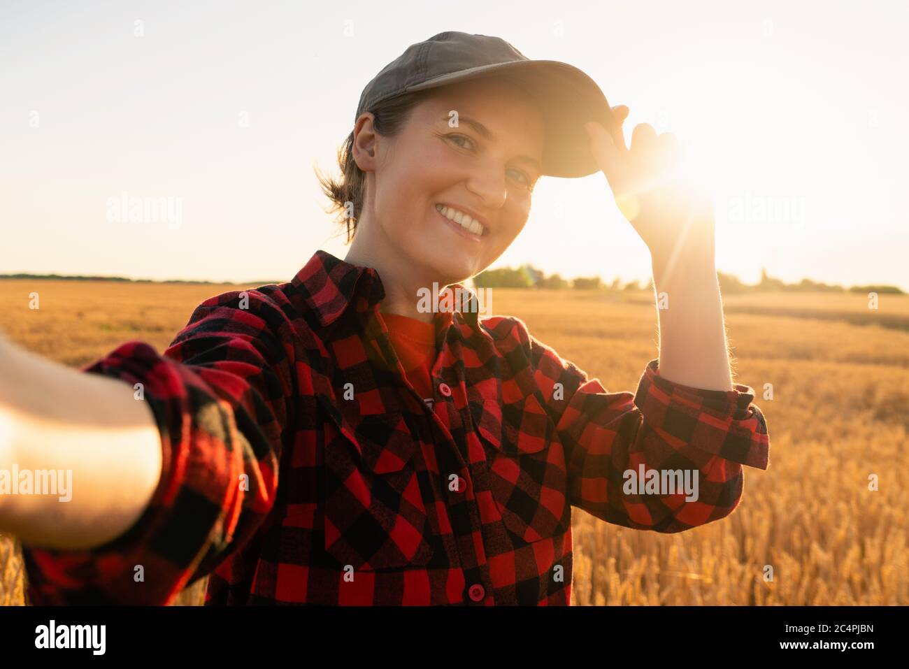 Woman farmer makes selfie on the background of a wheat field. Stock Photo