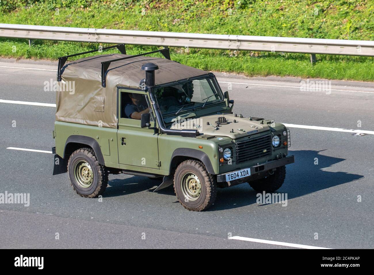 1999 90s green Army style SWB 2495 diesel Land Rover ; Vehicular traffic moving vehicles, cars driving vehicle on UK roads, motors, motoring on the M6 motorway highway network. Stock Photo