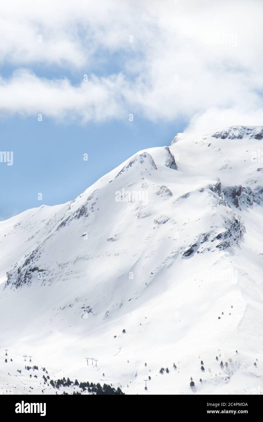 Snow-covered mountain side with ski slope Stock Photo