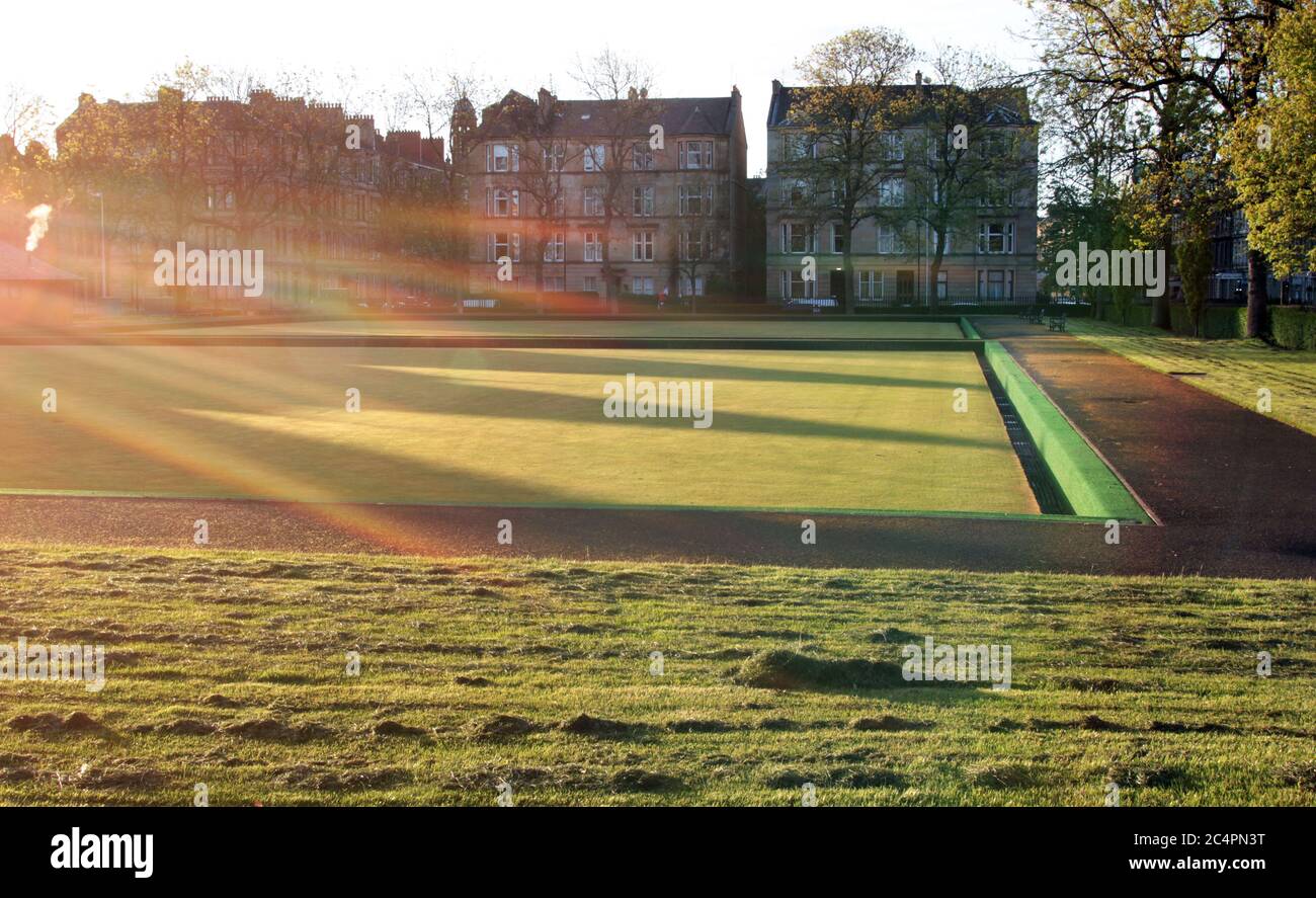 The very early morning sunshine flares across an empty bowling green producing an abstract show of light and shade and shadows in Glasgow. ALAN WYLIE/ALAMY© Stock Photo