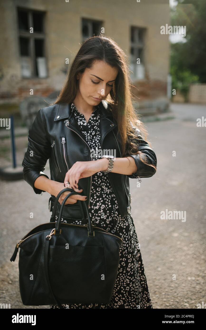 Attractive young woman with leather jacket standing outdoors. Stock Photo