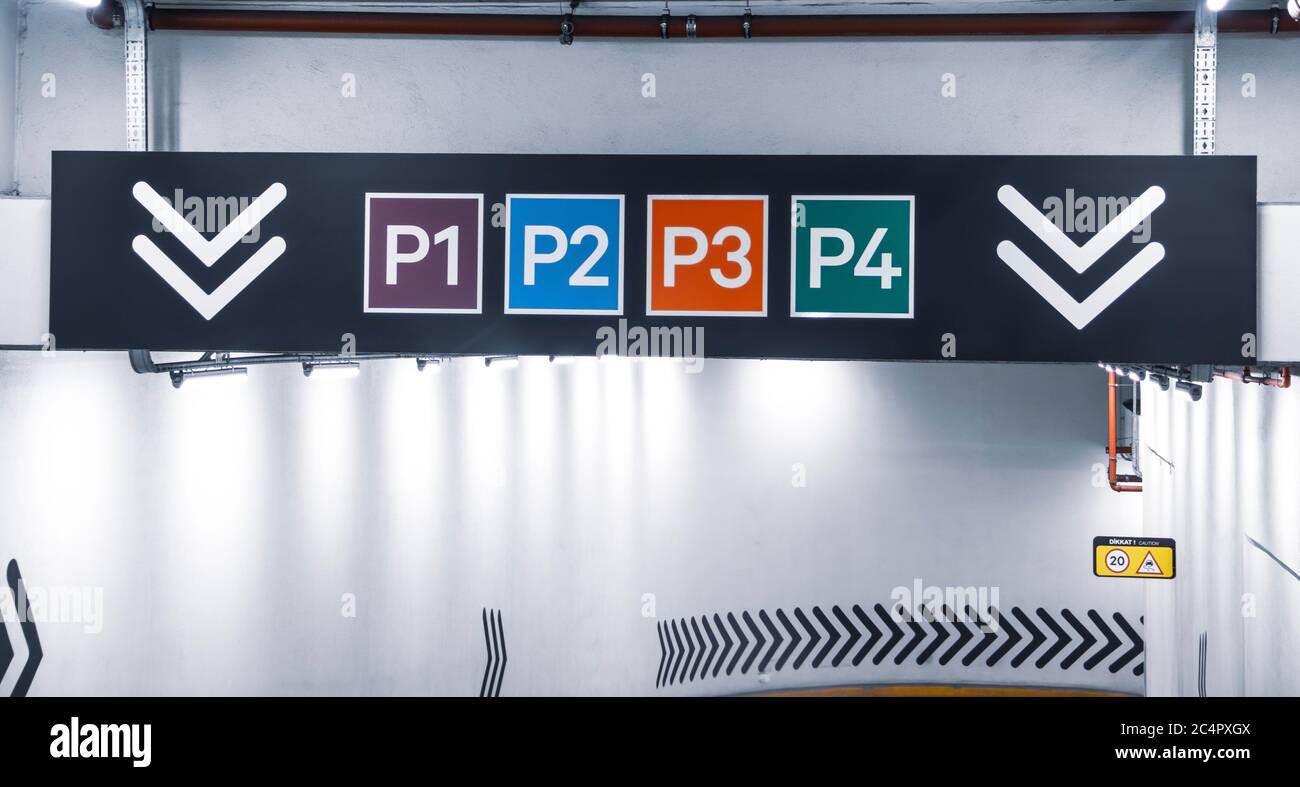 Colorful car parking floor level numbers sign above a ramp way. Stock Photo