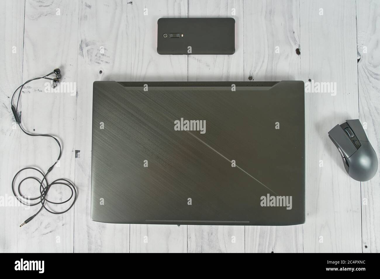 Notebook with cellphone headphones mouse on table Stock Photo