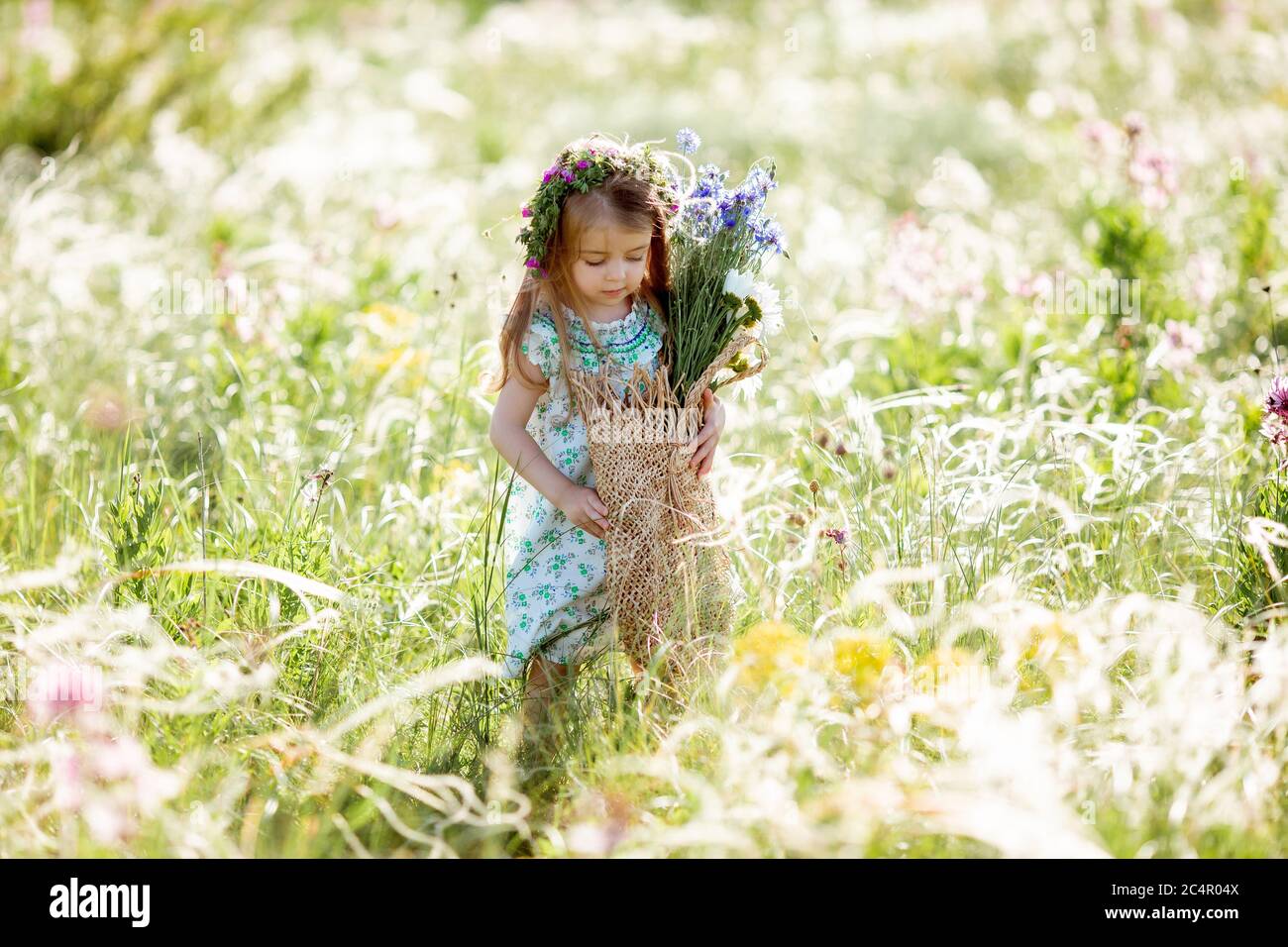 portrait of a cute little girl with a wreath on her head smiling ...