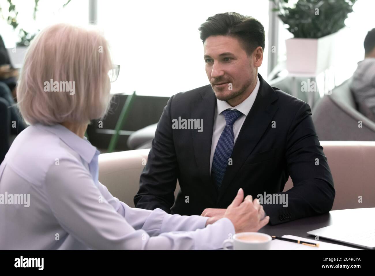 Two successful business people meeting in cafe and communicating Stock Photo