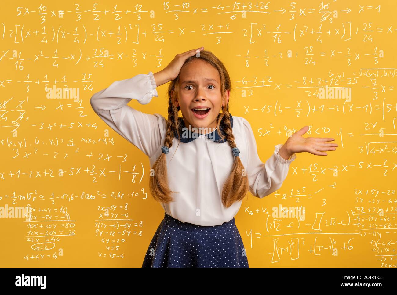 Young student is amazed about the difficulty of math problem. Yellow studio background Stock Photo