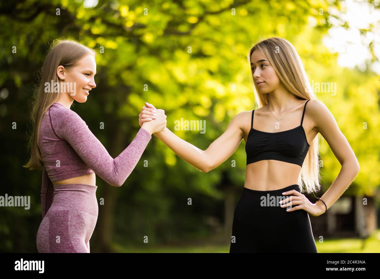 Two young sporty women giving each other a high five before workout ...