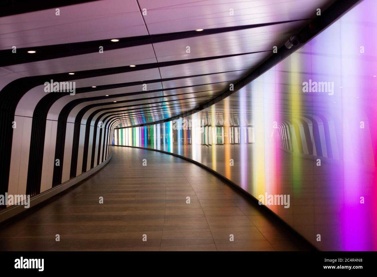 Interior of the illuminated colourful pedestrian light tunnel subway from One Pancras Square to King’s Cross St Pancras Underground Station in London, United Kingdom Stock Photo