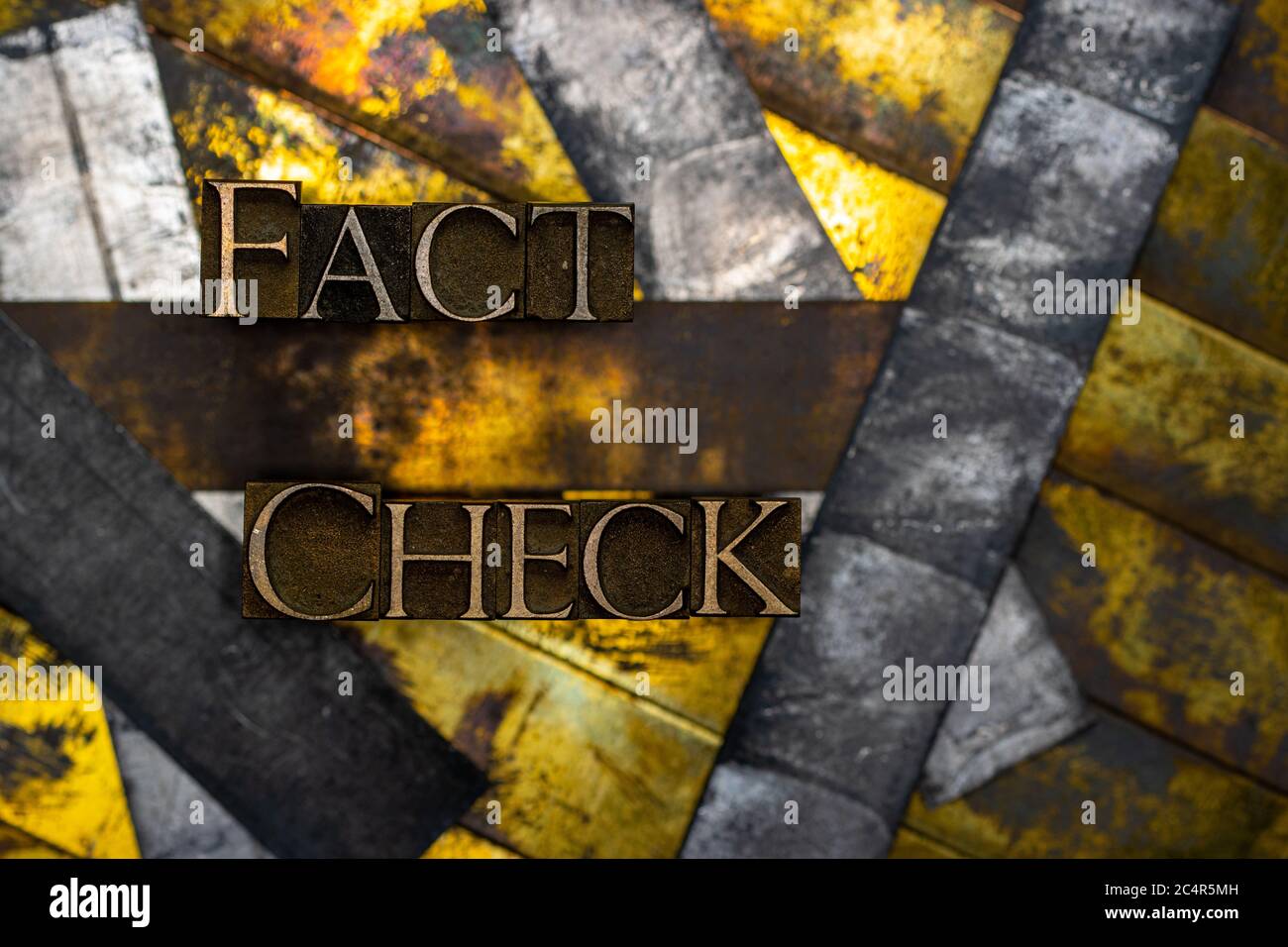 Fact Check text formed with real authentic typeset letters on vintage textured silver grunge copper and gold background Stock Photo