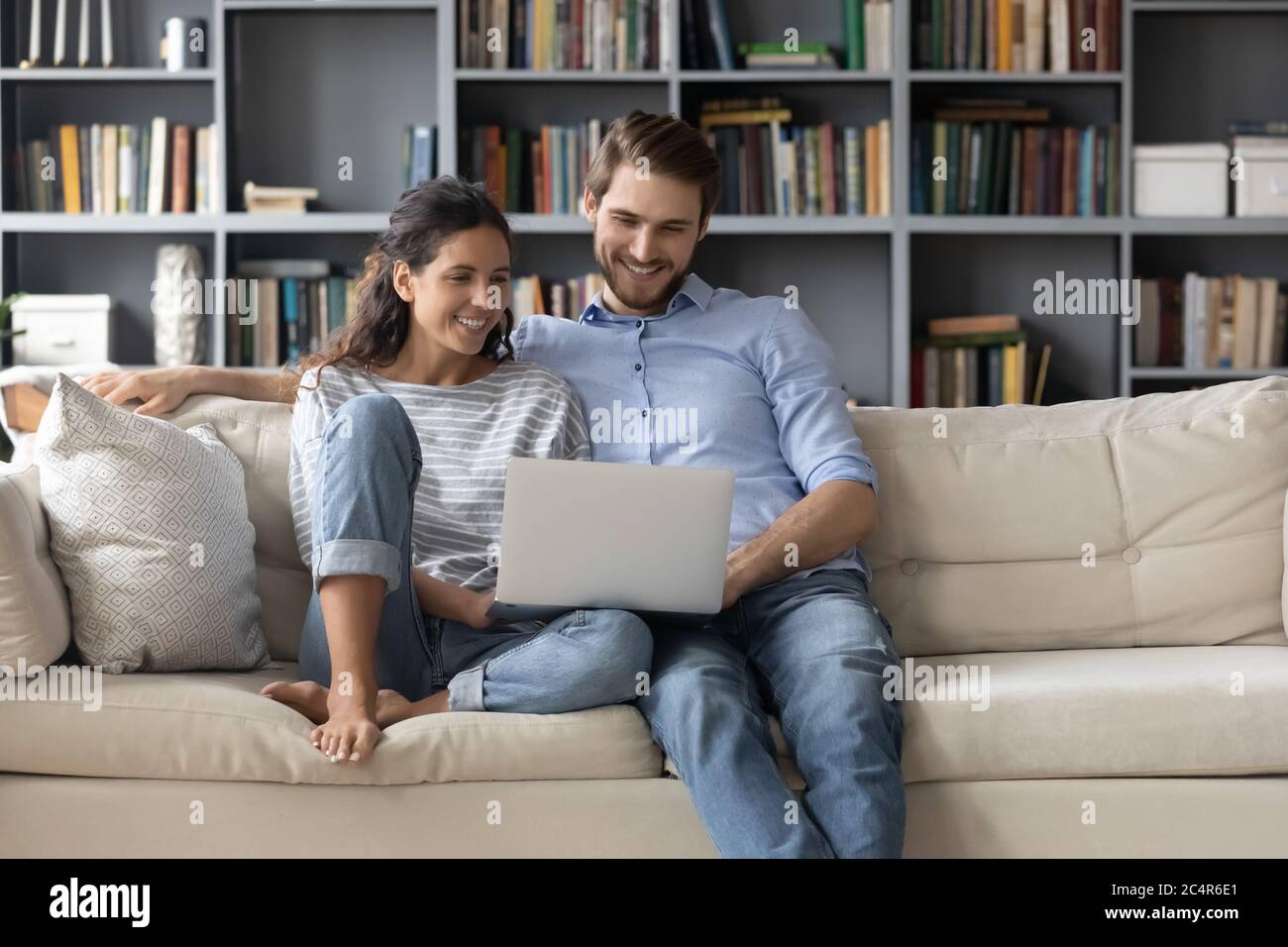 Smiling woman and man hugging, using laptop together Stock Photo - Alamy