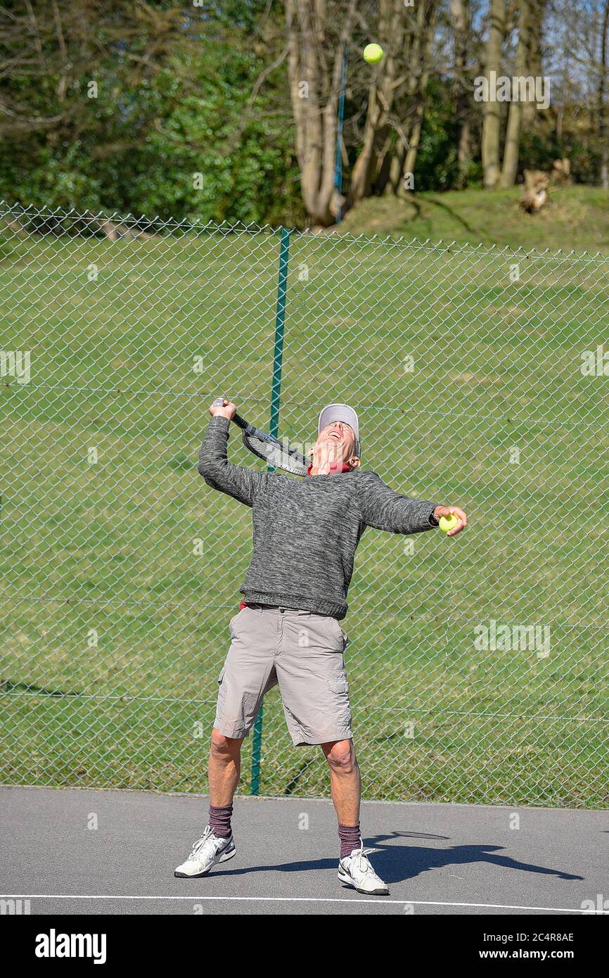 Retired elderly gentleman playing tennis. Stock Photo