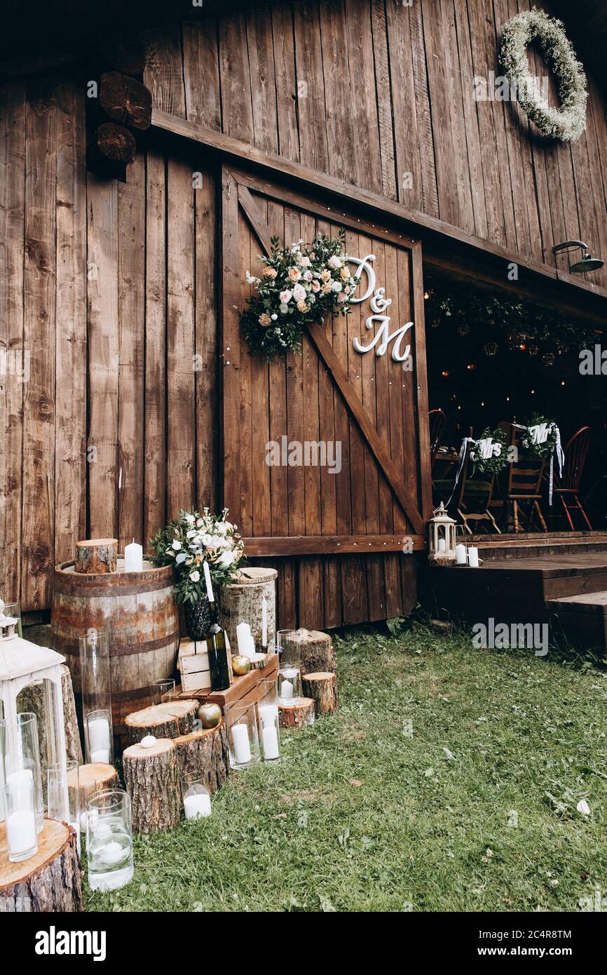 Close up of wooden rural restaurant with flowers, candles and paper letters. Beautiful view of wedding decoration and composition. Concept of style an Stock Photo