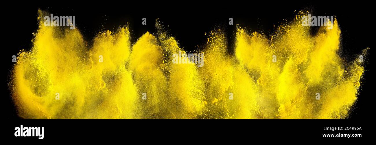 yellow holi paint color powder explosion isolated on dark black background. industry beautiful party festival concept Stock Photo