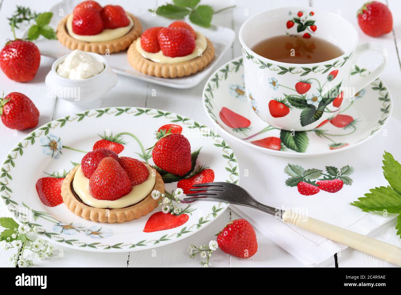 strawberry vanilla tartlets and porcelain with strawberry ornament Stock Photo
