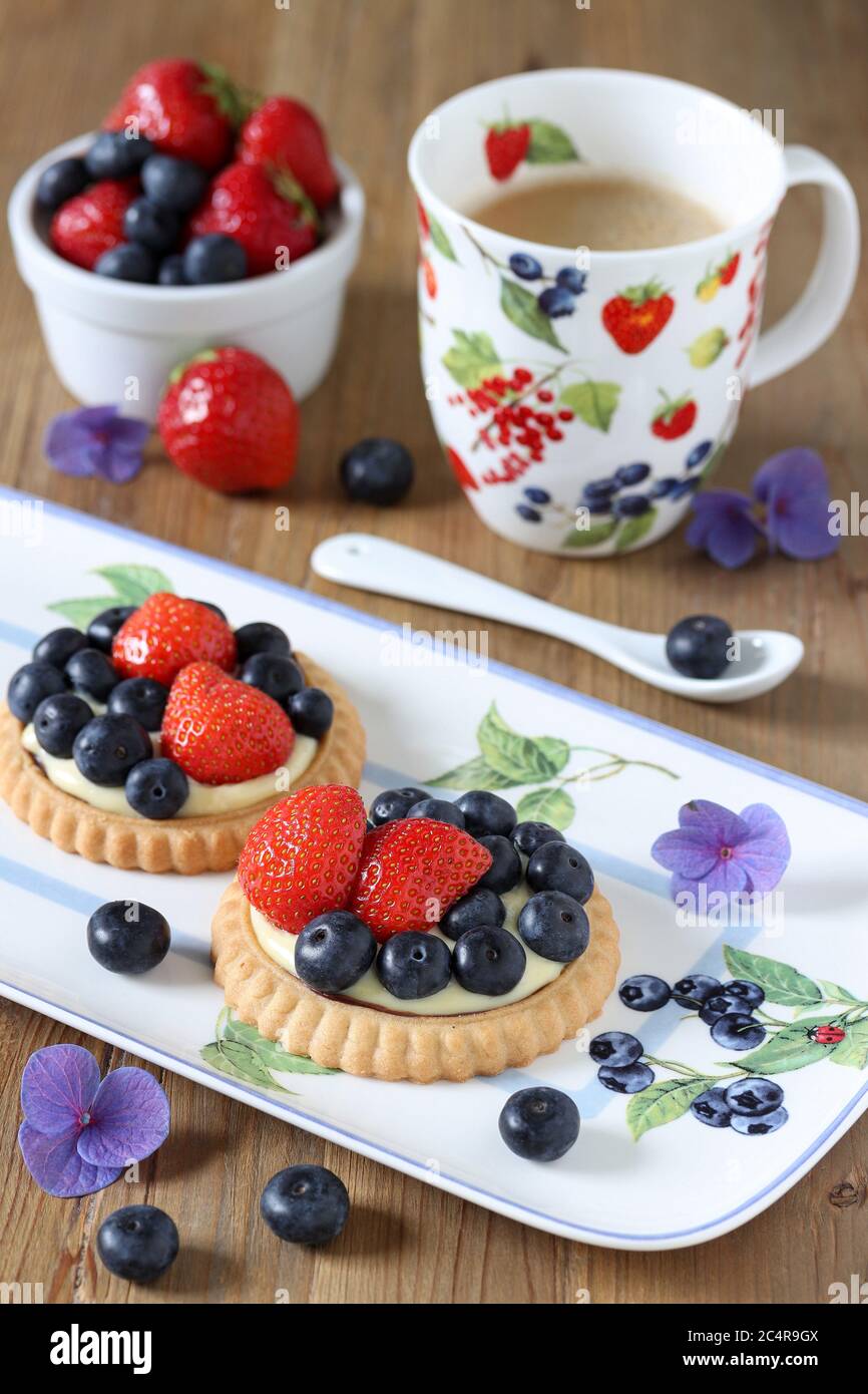 blueberry strawberry vanilla tartletes on cake plate Stock Photo