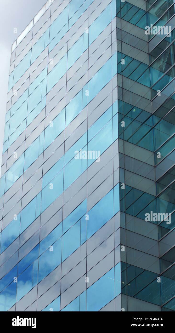 Modern building with glass windows reflected sky. Background in