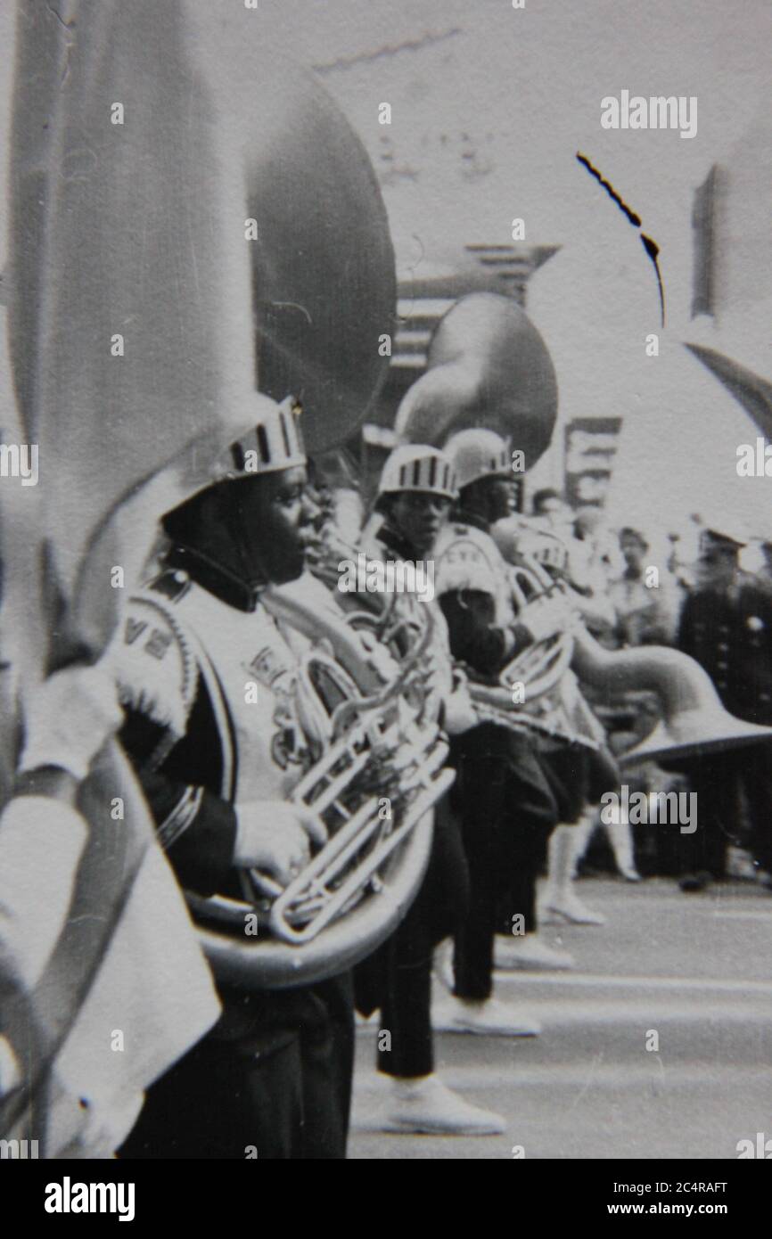 Fine 70s vintage black and white photography of a high school band playing the tuba while marching in a parade in downtown Chicago, Illinois. Stock Photo