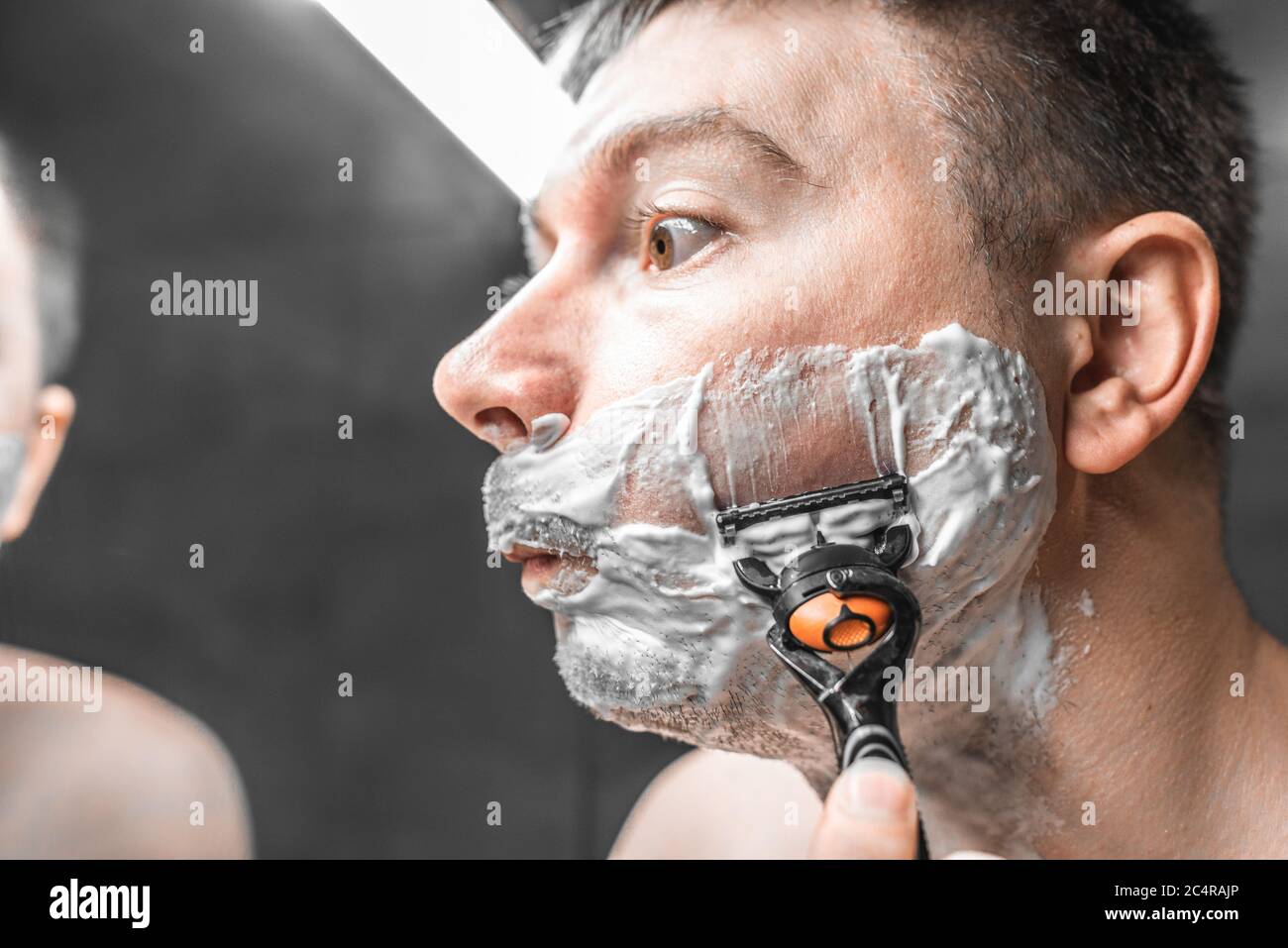 Guy looks in the mirror before shaving Stock Photo